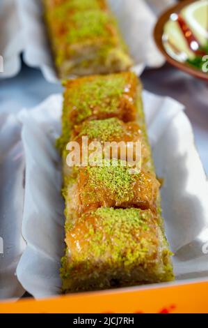 Dolce turco o arabo, baklava a base di pasta filo, ripieno di pistacchi tritati e zuccherato con sciroppo o miele, da vicino Foto Stock