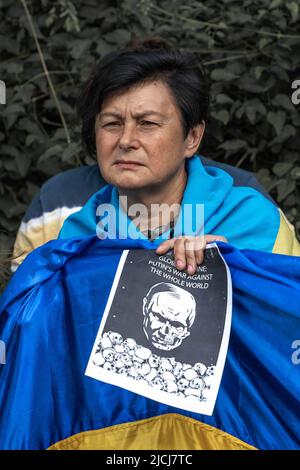 Sofia, Bulgaria, 13 giugno 2022: Una donna che detiene bandiera Ucraina e bandiera carestia globale - Putins guerra contro il mondo intero, si trova alla riunione ag Foto Stock