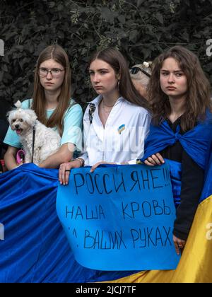 Sofia, Bulgaria, 13 giugno 2022: Tre ragazze hanno bandiera Ucraina e una bandiera russa - il nostro sangue è sulle vostre mani alla demonstraintion contro Foto Stock