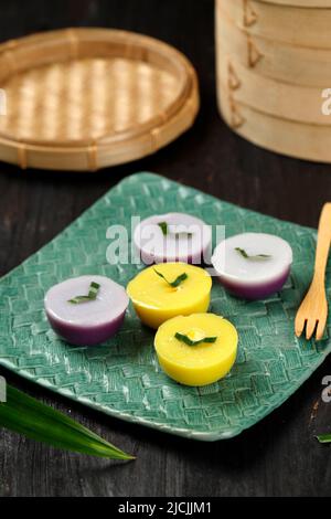 Talam Cake o in Indonesia chiamato Kue Talam Ubi Jagung con foglie di Pandan sulla parte superiore, serve su piastra in ceramica Foto Stock