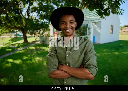 Misto razza maschio agricoltore sorridente in piedi all'aperto Foto Stock