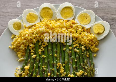 Asparagi verdi boild con uova bollite di mimosa. Foto Stock