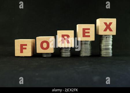 Forex o mercato di scambio di valuta estera crescita, redditività e concetto di investimento. Pila crescente di monete in blocchi di legno. Foto Stock