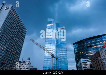 Grattacieli con gru che circondano Place Rogier a Bruxelles in una serata tempesta. Foto Stock