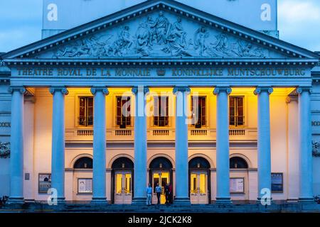 Facciata illuminata della Théâtre Royal de la Monnaie a Bruxelles, fotografata all'ora blu. Mix di luci. Foto Stock