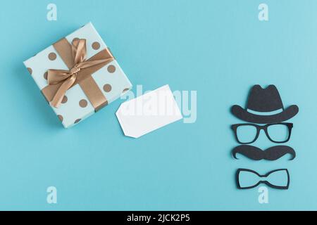 Buon giorno del Padre. Confezione regalo con carta e decorazione su sfondo blu. Spazio di copia. Foto Stock