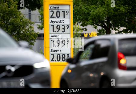 Amburgo, Germania. 14th giugno 2022. I prezzi dei carburanti possono essere visti sul display di una stazione di servizio, auto guidare di fronte ad essa. Credit: Daniel Reinhardt/dpa/Alamy Live News Foto Stock