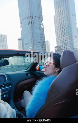 La giovane donna alla moda seduta nel co-pilota per un giro Foto Stock