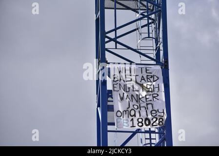 Salford, Regno Unito, 14th giugno 2022. Un uomo sta organizzando una protesta sopra una gru dall'inizio del 13th giugno a Chapel Street a Salford, Greater Manchester, Inghilterra, Regno Unito. Foto scattate la mattina del 14th giugno, alle 10,09 circa, circa 29 ore nella protesta. Diversi striscioni di protesta sono sulla gru. Credit: Terry Waller/Alamy Live News Foto Stock