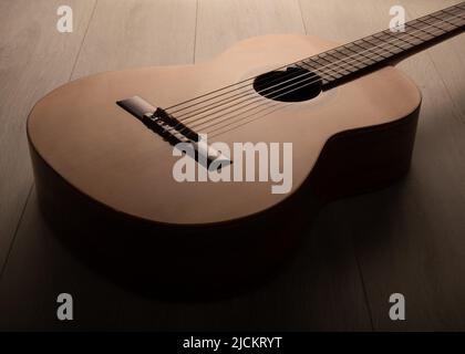 Il corpo della chitarra classica ha isolato drasticamente da vicino su uno sfondo chiaro. Foto Stock