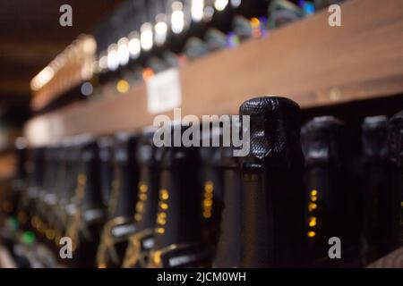 Bottiglie all'interno di una cantina sotterranea per la produzione di spumanti metodo tradizionale in italia Foto Stock