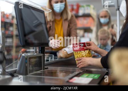 Checkout mani contatore del cassiere scansione alimentari in supermercato. Foto Stock