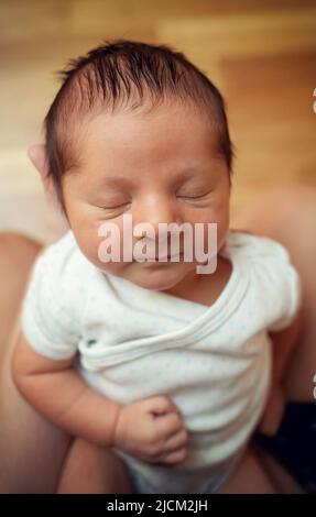 Primo piano di un neonato di pochi giorni con occhi chiusi. Concentratevi sulla testa, poi sui dettagli di capelli, occhi e naso. Foto Stock