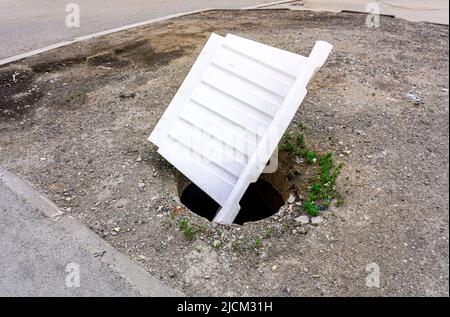 Aprire non protetta tombino fognario sulla via della città Foto Stock