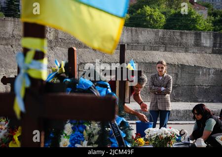 Lviv, Ucraina. 24th maggio 2022. Una donna gemeva alla tomba del suo parente. I pesanti combattimenti continuano nell'Ucraina orientale, con luoghi chiave sotto intenso bombardamento da parte delle forze russe. La Russia ha compiuto progressi lenti ma significativi a est, e ora controlla oltre il 90% della regione di Luhansk. Mentre la morte continua ad aumentare, la regione occidentale dell'Ucraina come la città di Lviv ha tenuto memoriali per il diminuito quasi ogni giorno dall'inizio della guerra, e non c'è fine in un breve periodo di tempo. (Credit Image: © Dominic Chiu/SOPA Images via ZUMA Press Wire) Foto Stock