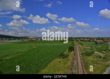 Nuvole di Cumulus tra campi verdi e cielo blu Foto Stock