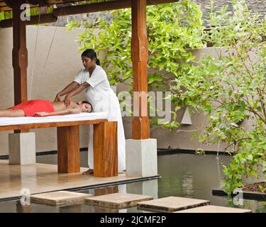 Una donna riceve un Massaggio di tessuti profondi presso la Sahana Spa, Saman Villas, Aturuwella, Bentota, Sri Lanka. Questo trattamento di massaggio si concentra sul più profondo l Foto Stock