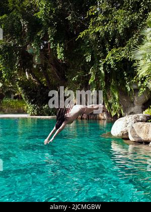 Donna che nuotano in una piscina del resort. Phuket, Tailandia. Foto Stock