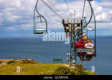 Needles, Isola di Wight, Regno Unito . Vista panoramica esterna delle persone e una sedia vuota sulla funivia per Alum Bay presso il punto di riferimento Needles Foto Stock