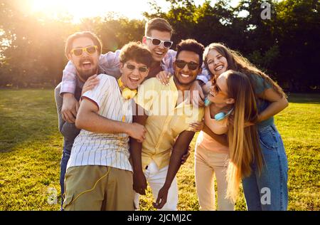 Gruppo di giovani amici allegri multirazziali che si divertono e si divertono nel parco estivo Foto Stock