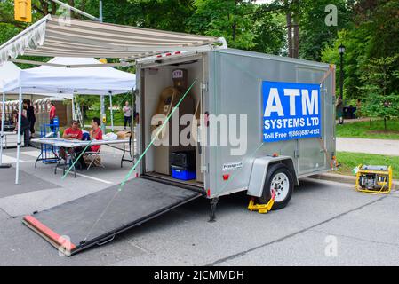 Un bancomat o le macchine automatiche del Teller funzionano in un carrello del rimorchio portatile. L'energia è fornita da un generatore portatile. Foto Stock