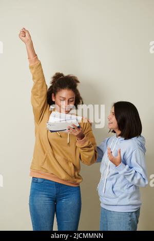 Ragazza felice eccitato che legge la lettera di accettazione dall'università Foto Stock