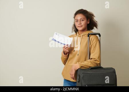Ragazza orgogliosa con la valigia che mostra lettera di accettazione da parte dell'università Foto Stock