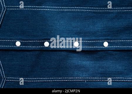 Texture jeans classica, primo piano. Giacca in denim blu, sfondo jeans. Abbigliamento per bambini o chioseup camicia, dettagli. Cuciture, bottoni metallici e rivetti Foto Stock