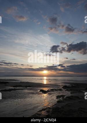 Un mix di nuvole al tramonto in una serata estiva a Nairn Beach. Vista verso la Black Isle. Foto Stock