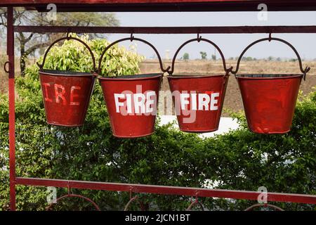 Secchielli antincendio rossi riempiti di sabbia per proteggere in caso di incendio sicurezza antincendio, secchiello riempito di sabbia utilizzare per prevenire il fuoco alla pompa benzina Foto Stock