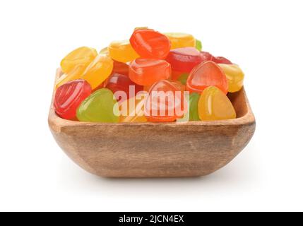 Vista frontale di colorate caramelle di frutta dura in ciotola di legno isolato su bianco Foto Stock