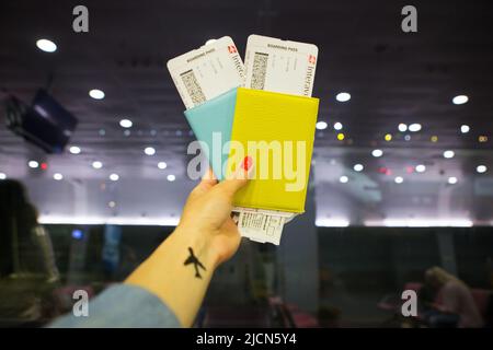 La ragazza tiene due passaporti nelle sue mani mentre si trova in aeroporto. Foto Stock