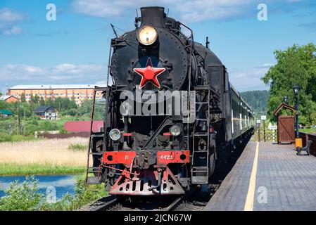 KARELIA, RUSSIA - 11 GIUGNO 2022: Una vecchia locomotiva a vapore L-4429 con un treno turistico retrò 'Ruskealsky Express' alla piattaforma della stazione. Karelia Foto Stock