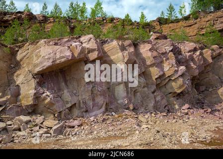 Una sezione di quarzite di cremisi in una vecchia cava. Villaggio di Kvartsitny, Karelia Foto Stock