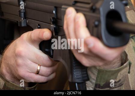 Un soldato ucraino in uniforme militare detiene una mitragliatrice, la guerra in Ucraina e la protezione della sua casa e famiglia 2022 Foto Stock