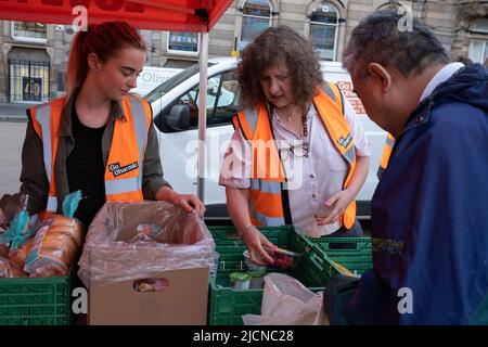 Glasgow, Regno Unito, 14 giugno 2022. Le persone si avvalgono di cibo gratuito presso la Food Bank, gestita dalla campagna Go Dharmic #FeedEveryone, che distribuisce migliaia di pasti in tutto il paese e si adopera per ridurre al minimo la crisi della #fame. Un evento settimanale a George Square, Glasgow, Scozia, il 14 giugno 2022. Photo credit: Jeremy Sutton-Hibbert/Alamy Live News. Foto Stock