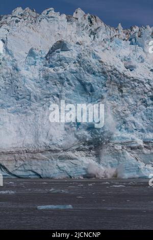 Il ghiaccio cade nell'acqua dal calvare al ghiacciaio Hubbard nella baia disincantata, Alaska, come visto da una nave da crociera. Foto Stock