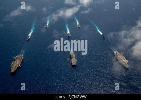 220612-N-DW158-1076 I velivoli DEL MARE FILIPPINO (12 giugno 2022) della Carrier Air Wing 9 volano in formazione sopra l'unica portaerei della Marina degli Stati Uniti USS Ronald Reagan (CVN 76), e USS Abraham Lincoln (CVN 72), e USS Tripoli (LHA 7), durante il Valiant Shield 2022 (VS22). VS22 è un'esercitazione biennale di formazione sul campo (FTX), riservata agli Stati Uniti, incentrata sull'integrazione della formazione congiunta in un ambiente multi-dominio. Questa formazione sviluppa una competenza reale nel sostenere le forze congiunte attraverso il rilevamento, la localizzazione, il tracciamento e l'impegno delle unità in mare, in aria, a terra e. Foto Stock