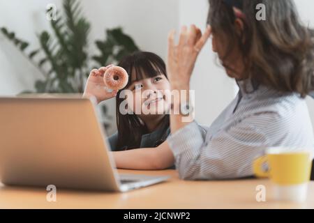 Momenti felici di nonna asiatica con sua nipote che parla e gioca insieme. Attività ricreative per i bambini a casa. Foto Stock