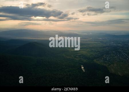 Vista aerea della pineta verde con abeti scuri che coprono le colline di montagna. Paesaggio boschivo del nord dall'alto Foto Stock