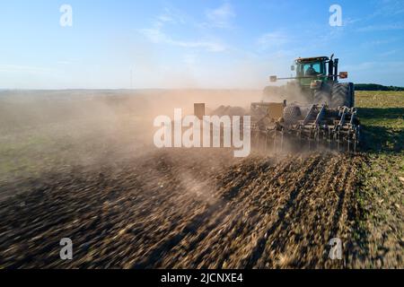 Vista aerea del trattore che aratura campo agricolo preparazione terreno per la semina in estate Foto Stock