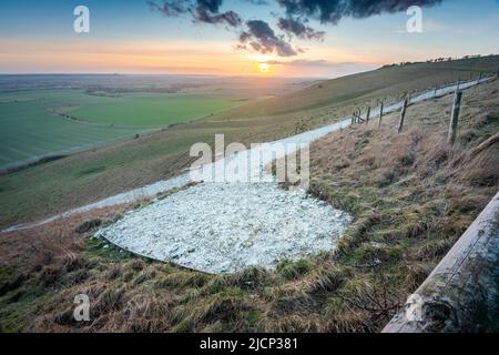 Ampia vista della coda di cavallo, il resto dell'iconica figura di collina di gesso, primo taglio nel 1812, che conduce lungo la collina, al tramonto nell'inverno inglese Foto Stock