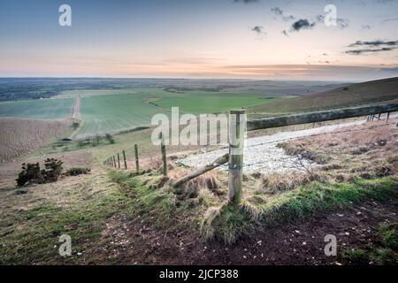 Ampia vista della coda di cavallo, il resto dell'iconica figura di collina di gesso, primo taglio nel 1812, che conduce lungo la collina, al tramonto nell'inverno inglese Foto Stock