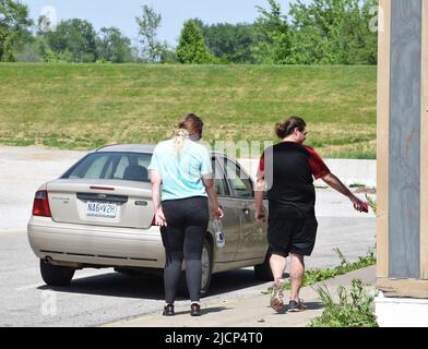 Uomo e donna tatuati o tatuati che camminano lungo una strada in una città del Midwest degli Stati Uniti Foto Stock