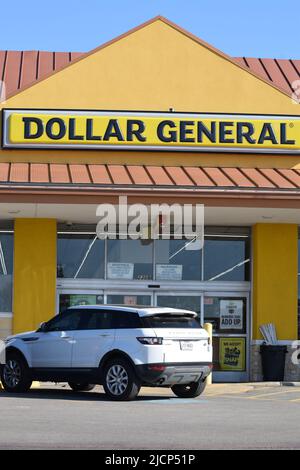 SUV bianco parcheggiato di fronte a un negozio Dollar General Foto Stock