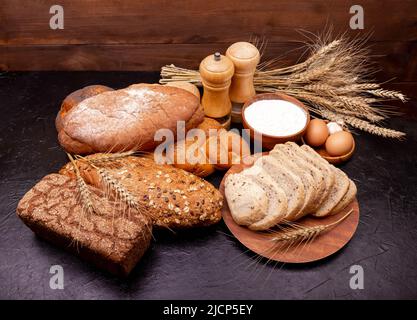 Composizione con pane e ingredienti per la cottura. Pane bianco e segale. Foto Stock