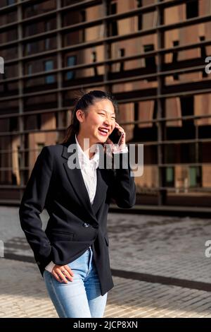 giovane donna d'affari che ride e parla per telefono Foto Stock