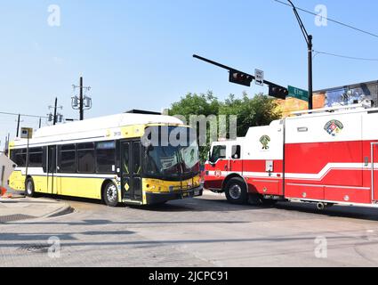 City of Dallas Fire Truck passando un autobus DART su Malcolm X Boulevard e Elm Street nella zona di Deep Ellum Foto Stock