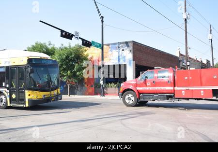 City of Dallas Fire Truck passando un autobus DART su Malcolm X Boulevard e Elm Street nella zona di Deep Ellum Foto Stock