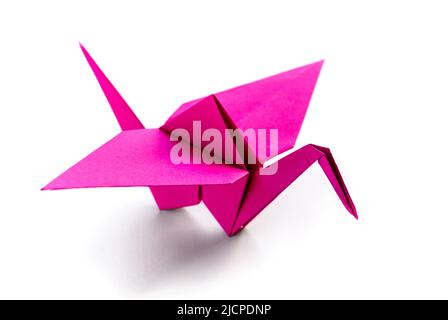 Origami della gru di carta rosa isolato su uno sfondo bianco bianco bianco bianco. Foto Stock